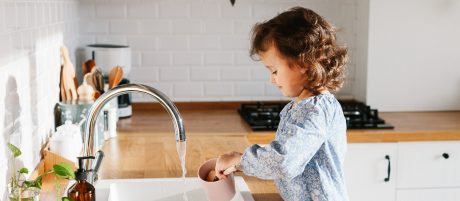 Djevojčica u kuhinji toči pitku vodu